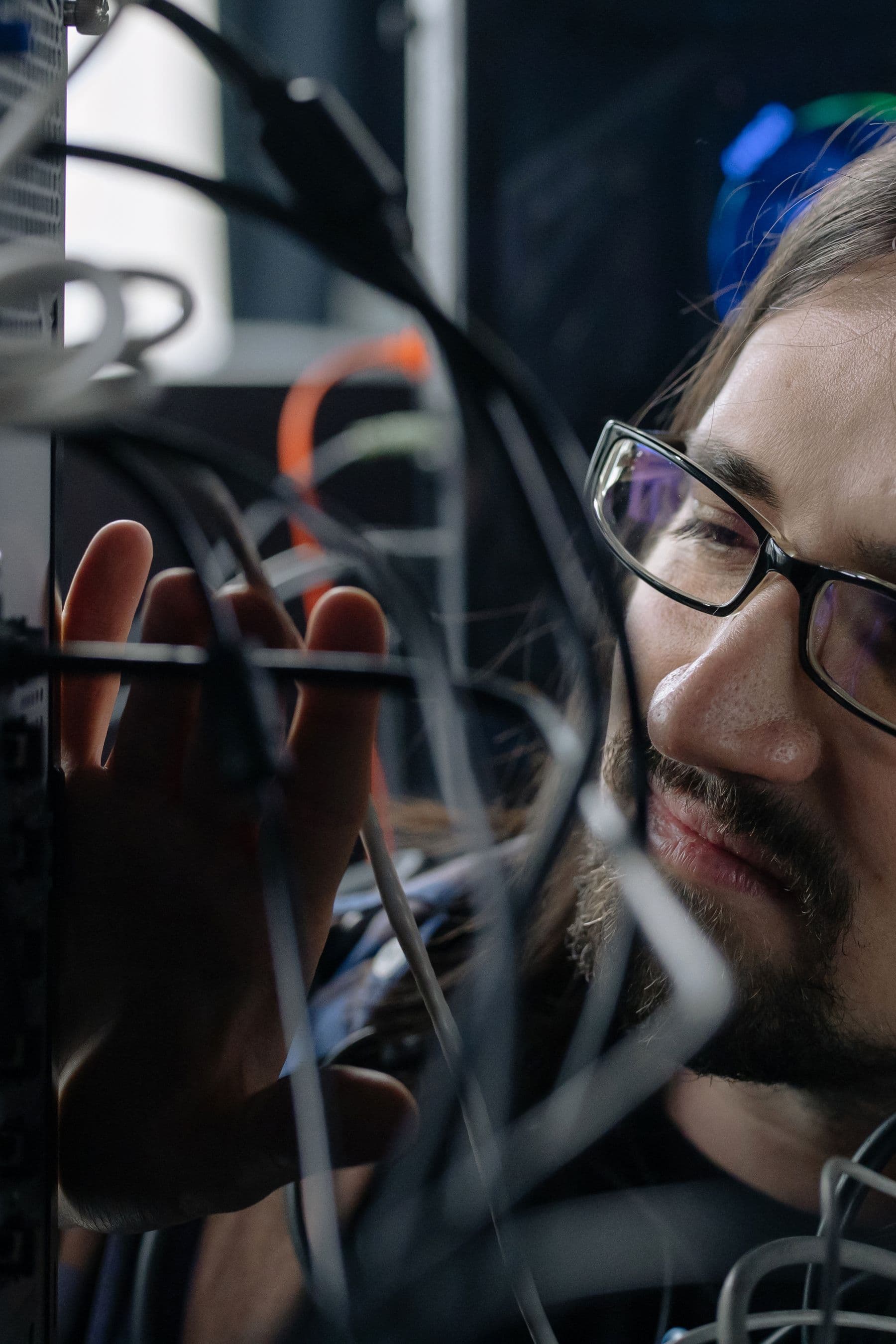 Onsite technician inspecting cabling inside a network rack